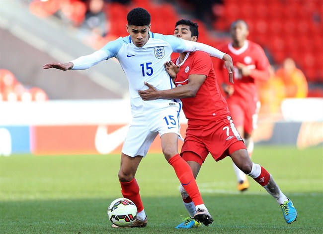 England's Ashley Fletcher, left, and Canada's Shamit Shome battle for the ball during their under-20 soccer match at the Keepmoat Stadium, Doncaster, England, Sunday March 27, 2016. Youth internationals Shome and Adonijah Reid are the first ever Generation Adidas Canada players. 