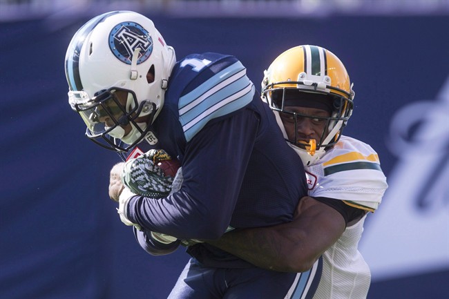 Toronto Argonauts running back Anthony Coombs, is tackled by Edmonton Eskimos cornerback Patrick Watkins during a CFL game in Toronto on Aug. 20, 2016.