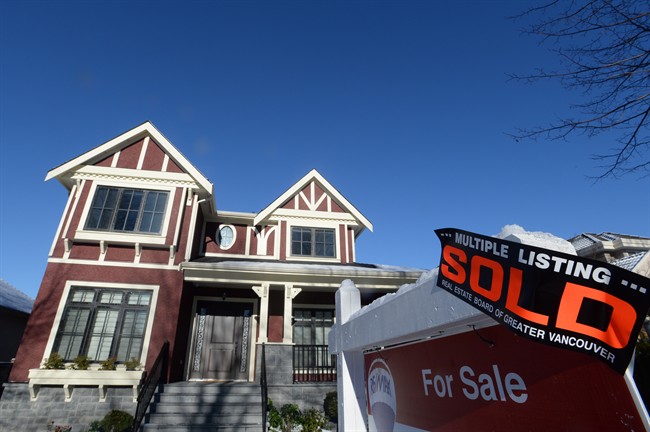A real estate sold sign is shown outside a house in Vancouver on Tuesday, Jan.3, 2017.