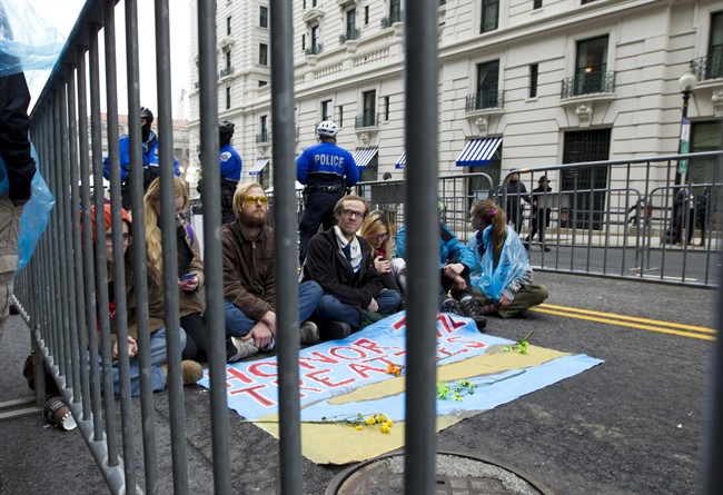 Demonstrators sit at the entrance of a security checkpoint, to block people to enter, Friday, Jan. 20, 2017, during the inauguration of President Donald Trump in Washington.