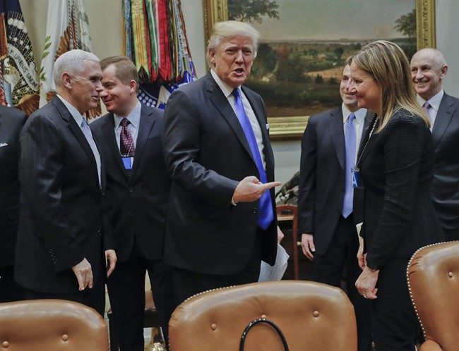 President Donald Trump gestures towards GM CEO Mary Barra, right, before the start of a meeting with automobile leaders in the Roosevelt Room of the White House in Washington, Tuesday, Jan. 24, 2017.