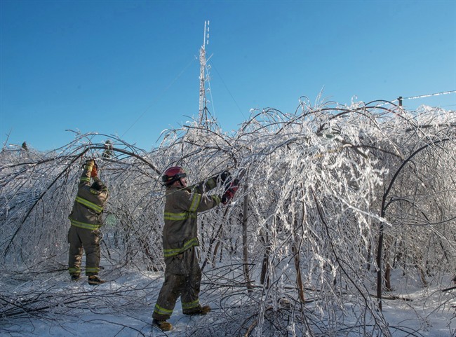 Members of the Baie Sainte Anne Fire Department clear a road so technicians can get to the emergency radio repeater tower to charge the batteries in Escuminac, NB. on Sunday, Jan. 29, 2017. 