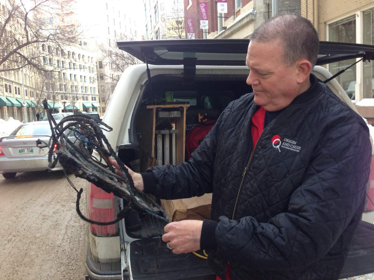Fire investigator Ken Swan holds up an extension cord that sparked, and caused a house fire.