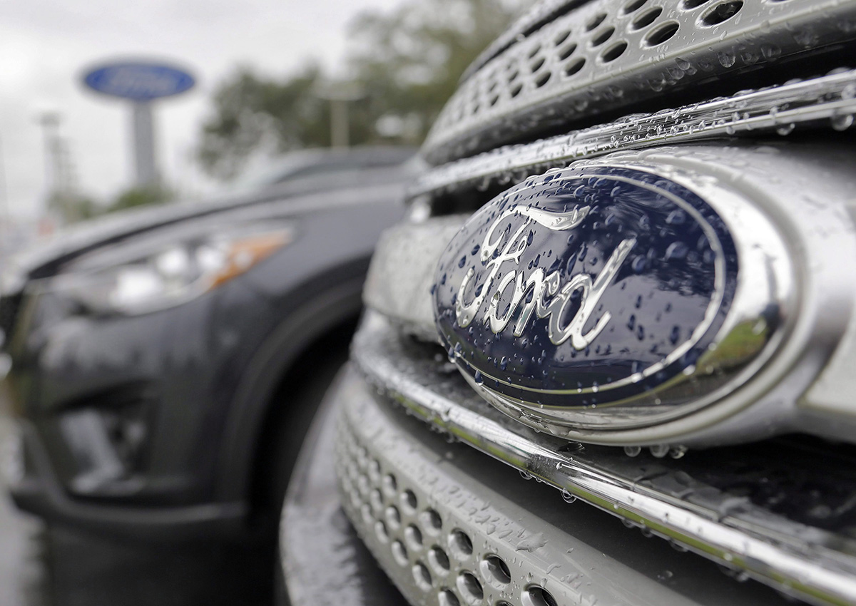 In this Jan. 12, 2015, file photo, Ford vehicles sit on the lot at a car dealership, in Brandon, Fla. Ford Motor Co. expects its pretax profit to fall in 2017 but improve in 2018 as it invests in emerging businesses. Ford updated its outlook Wednesday, Sept. 14, 2016, at its annual investor day.