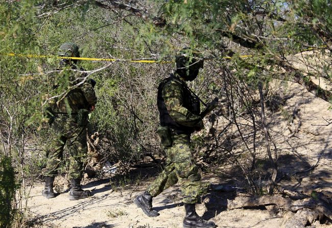 In this May 18, 2012 file photo, Mexican soldiers patrol an area of Monterrey, Nuevo Leon state in Mexico where clandestine graves were found.