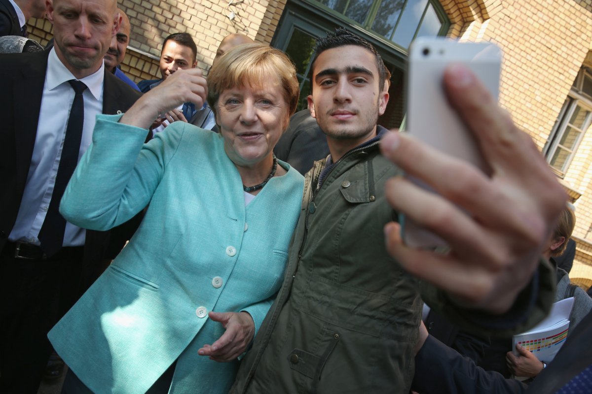 German Chancellor Angela Merkel poses for a selfie with a migrant from Syria after she visited the AWO Refugium Askanierring shelter for migrants on September 10, 2015 in Berlin, Germany. 