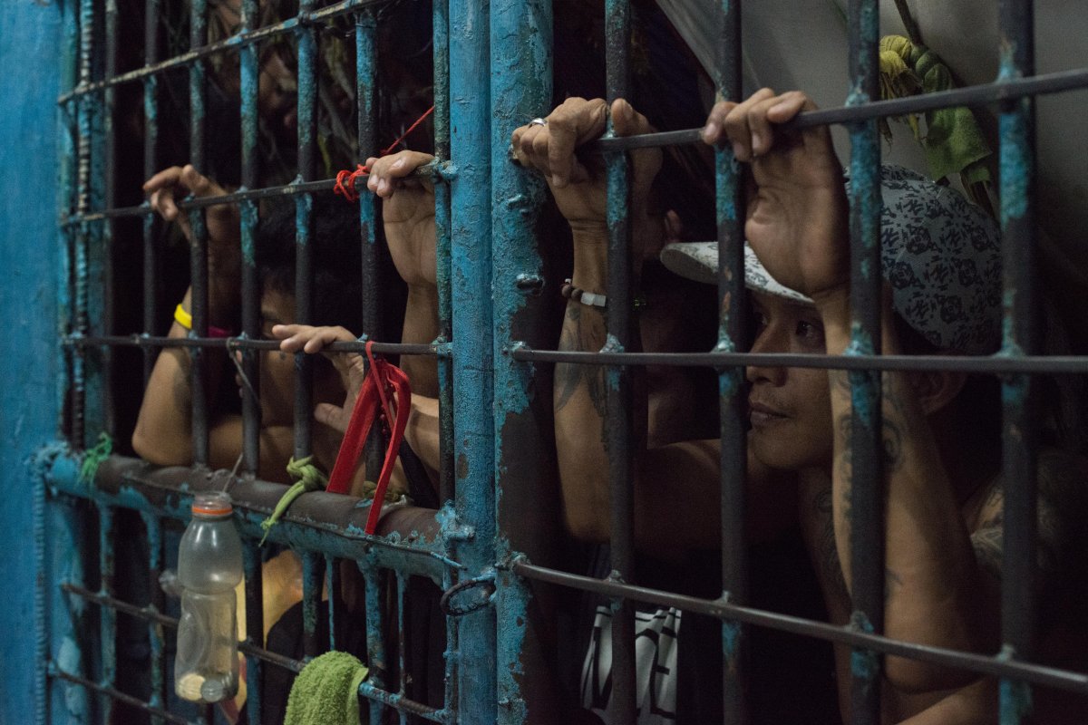Inmates look outside from an overcrowded jail cell inside a police precint jail on December 15, 2016 in Manila, Philippines. 
