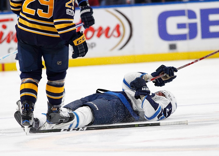 Winnipeg Jets forward Patrik Laine lays on the ice after a check by Jake McCabe of the Buffalo Sabres during Saturday's game at the KeyBank Center in Buffalo, N.Y..