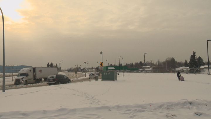 A woman treks through the snow with her suitcase after getting off of a Greyhound bus on Jan. 9, 2017.