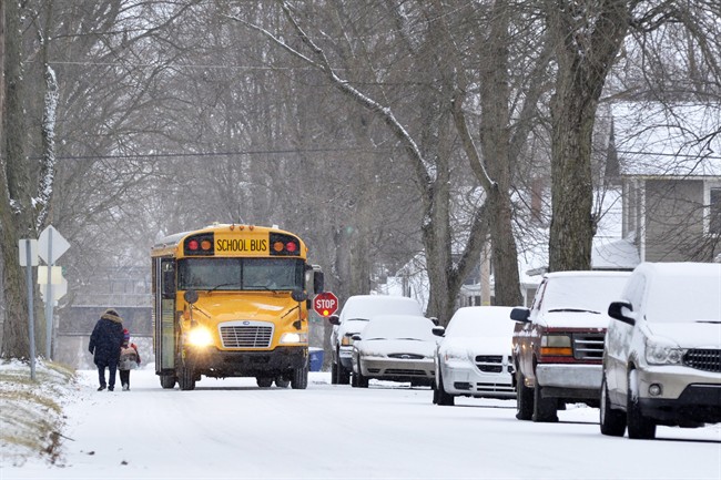 A young bus rider gets an escort through the cold after school in Marion, Ind., on Thursday, Jan. 5, 2017.