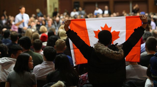 An audience member holds a Canadian Flag as Prime Minister Justin Trudeau speaks during a town hall meeting at Alumni Hall, Western University on Friday, Jan. 13, 2017, in London, Ontario. 
