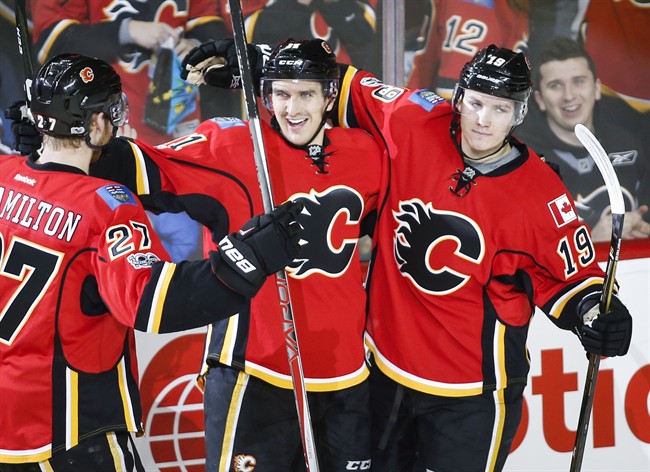 Calgary Flames' Mikael Backlund, centre, from Sweden, celebrates his goal with Dougie Hamilton, left, and Matthew Tkachuk during second period NHL hockey action against the Colorado Avalanche in Calgary, Wednesday, Jan. 4, 2017.