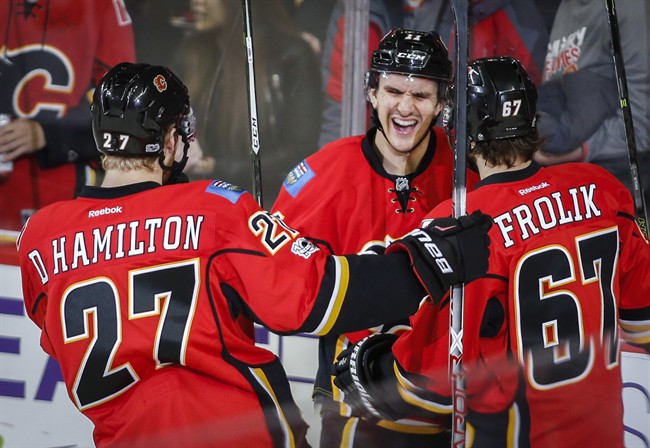 Calgary Flames' Mikael Backlund, centre, from Sweden, celebrates his first goal with teammates during second period NHL hockey action in Calgary, Tuesday, Jan. 17, 2017.