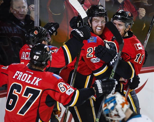 Calgary Flames' Dougie Hamilton, centre right, celebrates his game-winning goal with teammates during third period NHL hockey action against the San Jose Sharks in Calgary, Wednesday, Jan. 11, 2017.