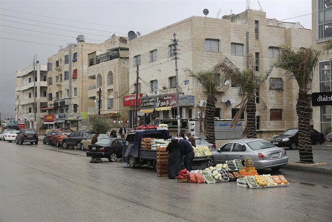 A vendor sells produce from a truck in the Thraa al-Gharbi neighbourhood in Amman, Jordan on Sat. Jan. 28, 2017. (AP Photo/Sam McNeil)