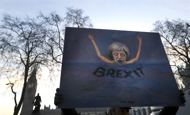 Artist Kaya Mar holds a painting near Parliament in London, Tuesday, Jan. 24, 2017. Lead plaintiff Gina Miller says British Supreme Court ruling provides the legal foundation to trigger Brexit. (AP Photo/Kirsty Wigglesworth).