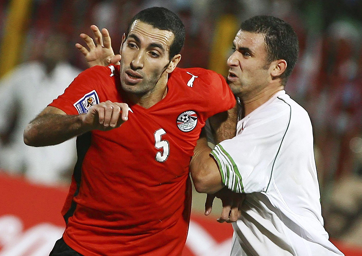 Egyptian soccer player Mohamed Aboutrika, left, is caught by  Algerian Yazid Mansouri, during their World Cup qualifying playoff  Group Csoccer match in Khartoum, Sudan, Wednesday, Nov. 18, 2009. 