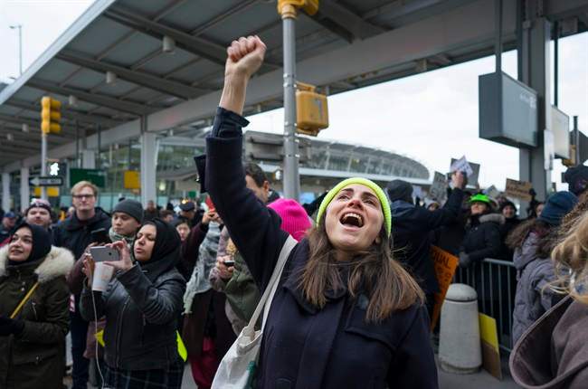A protester raises her fist and shouts as she joins others assembled at John F. Kennedy International Airport in New York, Saturday, Jan. 28, 2017 after two Iraqi refugees were detained while trying to enter the country. On Friday, Jan. 27, President Donald Trump signed an executive order suspending all immigration from countries with terrorism concerns for 90 days. Countries included in the ban are Iraq, Syria, Iran, Sudan, Libya, Somalia and Yemen, which are all Muslim-majority nations. (AP Photo/Craig Ruttle).