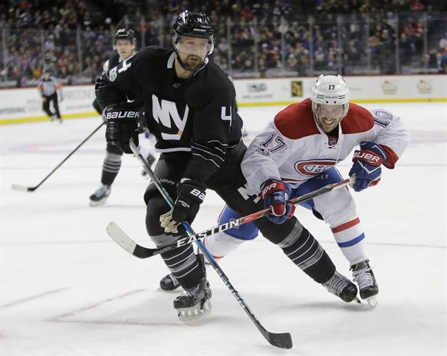 Montreal Canadiens' Torrey Mitchell (17) and New York Islanders' Dennis Seidenberg (4) fight for position during the first period of an NHL hockey game Thursday, Jan. 26, 2017, in New York.