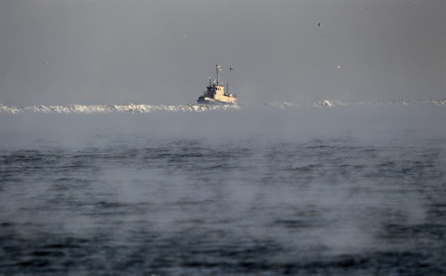 A search vessel travels amidst the morning fog near a break wall at Lake Erie to help in the recovery operation of a missing plane, Jan 6, 2017.