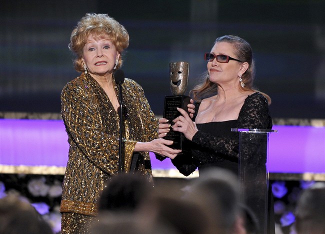 Carrie Fisher, right, presents her mother Debbie Reynolds with the Screen Actors Guild life achievement award at the 21st annual Screen Actors Guild Awards at the Shrine Auditorium in Los Angeles in this Jan. 25, 2015 file photo.