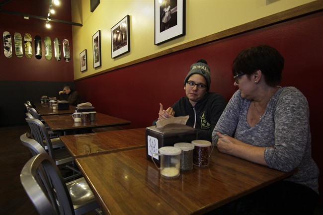 In this Jan. 9, 2017, photo, Andrea Ledesma, 28, second from right, talks with her mother, Cheryl Romanowski, at Classic Slice pizza restaurant, where Ledesma works, in Milwaukee. 