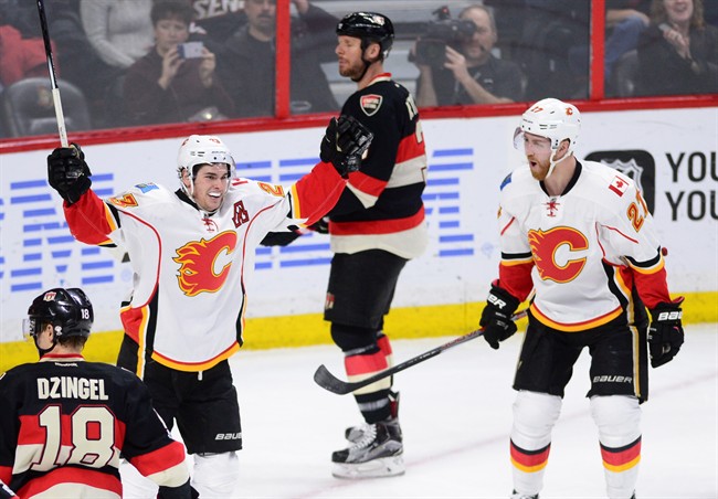 Calgary Flames centre Sean Monahan (23), left, celebrates his goal with defenceman Dougie Hamilton (27) as Ottawa Senators defenceman Marc Methot (3) and left wing Ryan Dzingel (18) skate past during second period NHL hockey action in Ottawa on Thursday, Jan. 26, 2017. 