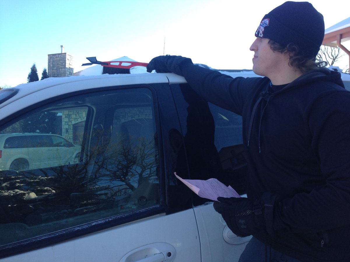 Jonathan Mcculough clears snow off his van, after receiving a fine of $237.50.