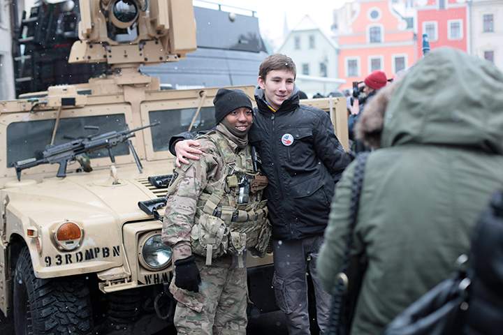 A man poses for photos with a member of the US army (L) during an official welcome event for the US army in Zagan, west Poland, January 14, 2017.
