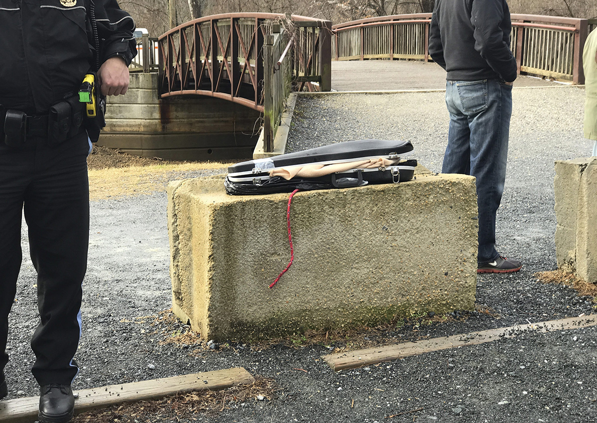 This image provided by Barbara Joan Saffir, shows police standing near a violin case along the Potomac River in Washington, Wednesday, Jan. 4, 2017. 