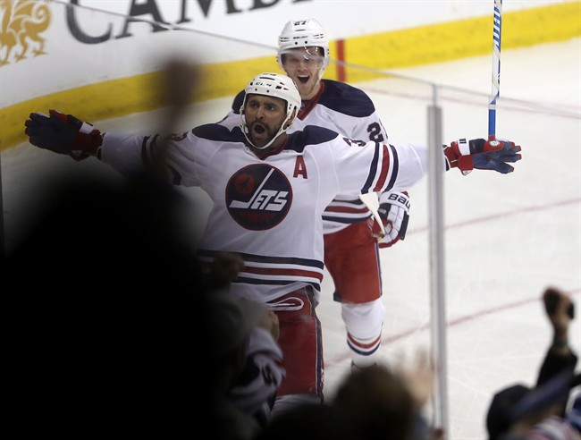 Winnipeg Jets defenceman Dustin Byfuglien (33) celebrates with right wing Nikolaj Ehlers (27) after scoring against the Calgary Flames during first period NHL hockey action in Winnipeg, Monday, January 9, 2017.