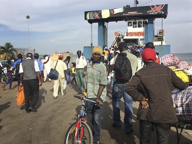 People board the ferry leaving Banjul, Gambia, Wednesday Jan. 18, 2017. Special flights were being organized Wednesday to evacuate British and other tourists from Gambia, where the threat of a regional military intervention loomed as President Yahya Jammeh's mandate expires on Thursday after he lost elections in December. On Tuesday, he declared a state of emergency before he is supposed to cede power to President-elect Adama Barrow.