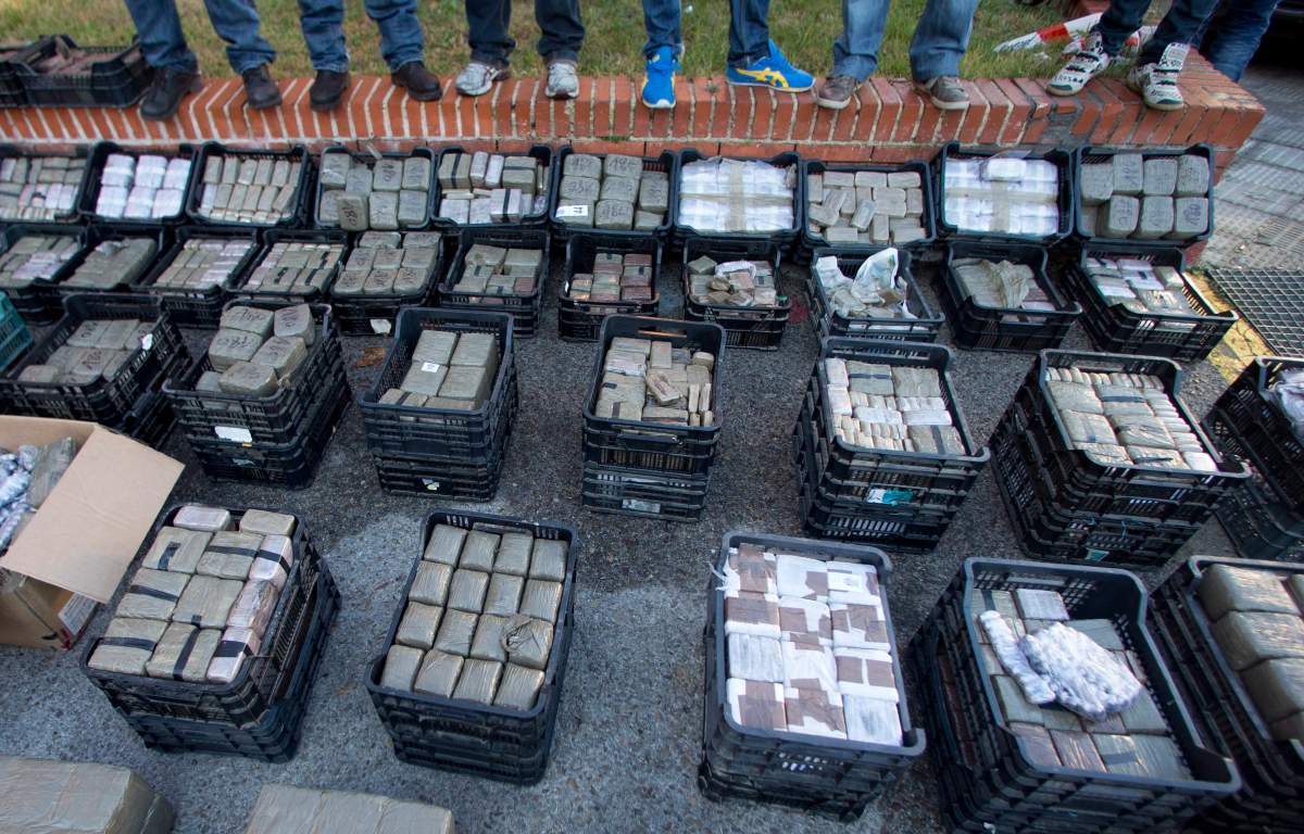 Police officers stand on a wall looking at part of a haul of hashish and marijuana in Madrid, Wednesday Dec. 26, 2012.