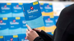 A person holds a version of TurboTax software.