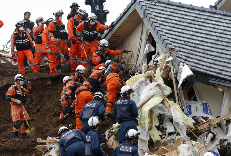 Rescue workers search for missing people at the site of a landslide triggered by an earthquake in southwestern Japan, 19 April 2016. 