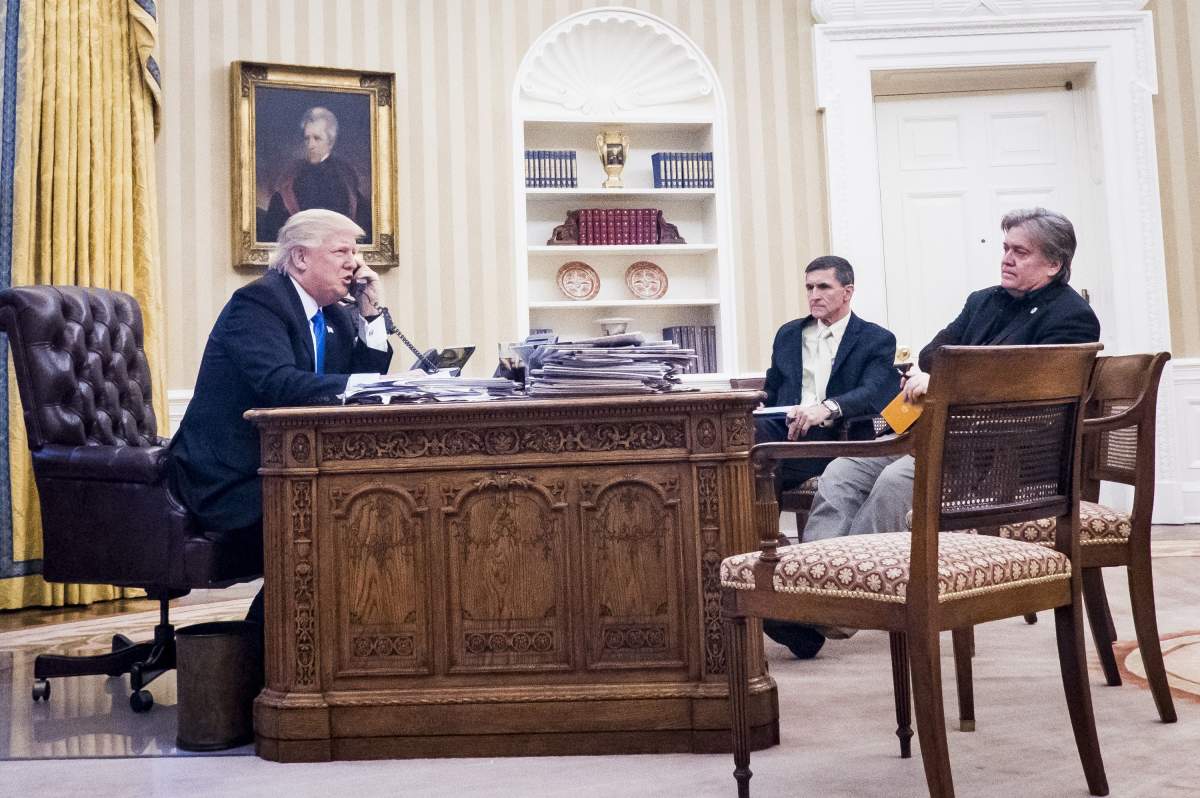 National Security Advisor Michael Flynn and Senior Counselor to the President Steve Bannon, sit nearby as United States President Donald Trump speaks on the phone with Prime Minister of Australia, Malcolm Turnbull in the Oval Office.