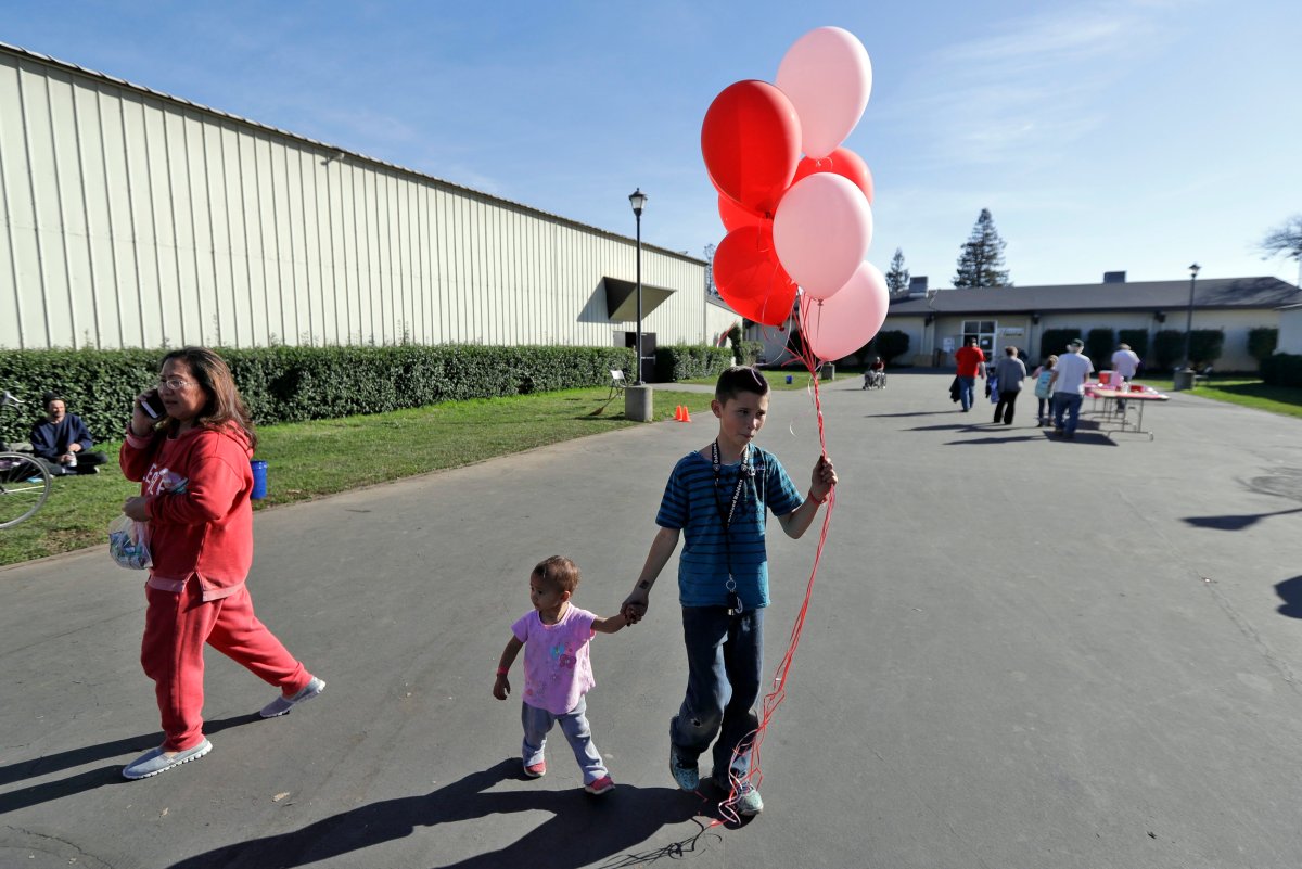 Anthony Bradley, 12, center right, of Oroville, Calif., leaves a shelter with some balloons alongside his one-year-old niece Aunia Steele after a mandatory evacuation was lifted Tuesday, Feb. 14, 2017, in Chico, Calif.