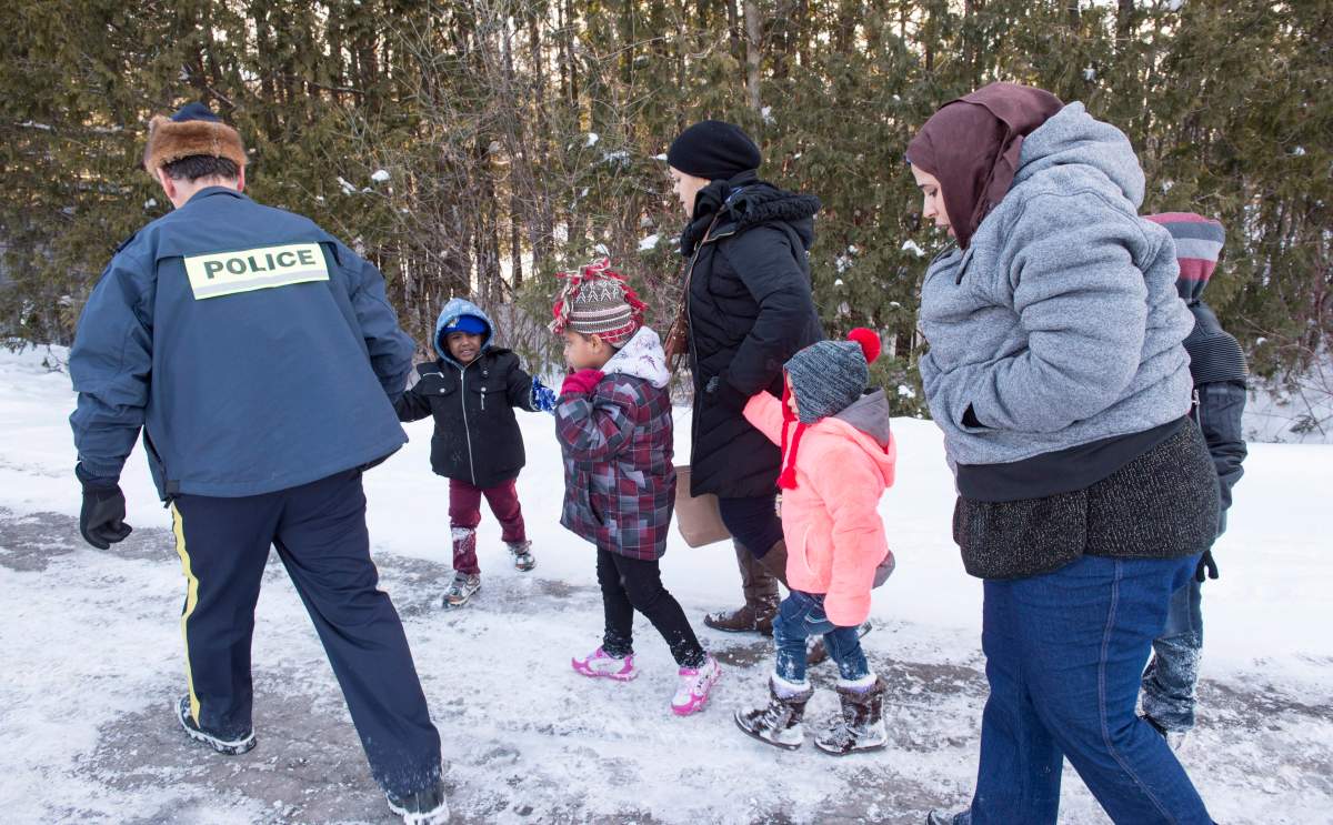 Family members from Somalia are escorted by RCMP officers after crossing the U.S.-Canada border near Hemmingford, Que., on Friday, Feb. 17, 2017.