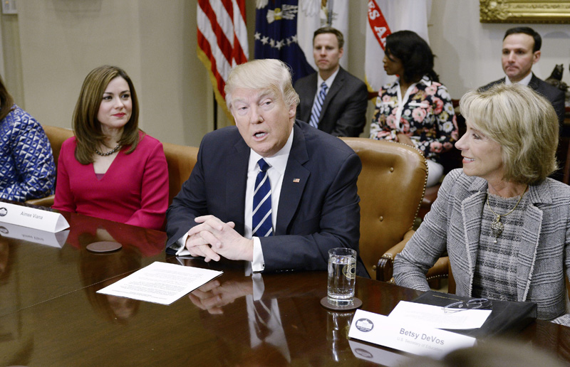 U.S. President Donald Trump, flanked by Education Secretary Betsy DeVos (right) speaks during a parent-teacher conference listening session at the White House in Washington, DC.