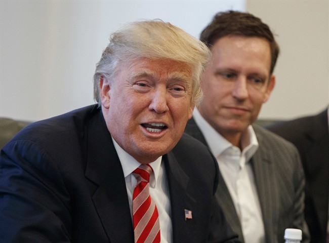  In this Wednesday, Dec. 14, 2016, file photo, PayPal founder Peter Thiel, right, listens as then President-elect Donald Trump speaks during a meeting with technology industry leaders at Trump Tower in New York.