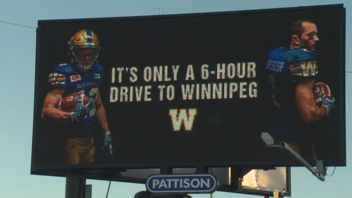 The billboard that the Winnipeg Blue Bombers put up on the corner of Dewdney Avenue and Lewvan Drive shows an image of former Rider receivers Weston Dressler and Ryan Smith beside text letting people know that Winnipeg is only a six hour drive from Regina.