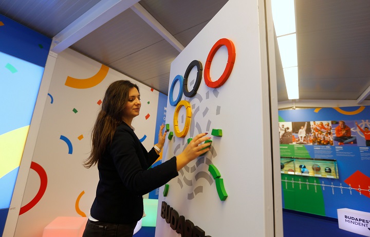 A hostess adjusts the Olympic rings at a promotional spot as the Hungarian capital bids for the 2024 Olympic Games, in central Budapest, Hungary January 31, 2017. Picture take January 31, 2017. REUTERS/Laszlo Balogh.