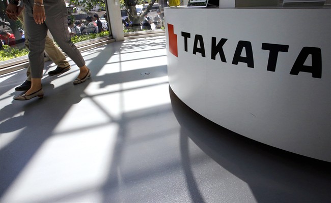 In this May 4, 2016, file photo, visitors walk by a Takata Corp. desk at an automaker's showroom in Tokyo.