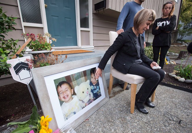Tima Kurdi, touches a photo of her nephews Alan, left, and Ghalib Kurdi while speaking to the media outside her home in Coquitlam, B.C., on Thursday, Sept. 3, 2015.