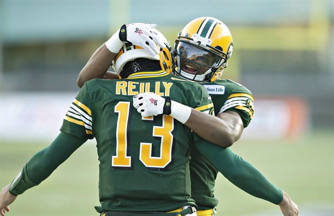 Edmonton Eskimos' quarterback Mike Reilly (13) and Shamawd Chambers (17) celebrate a touchdown against the Calgary Stampeders during first half action of the CFL West Division final in Edmonton, Alta., on Sunday November 22, 2015.