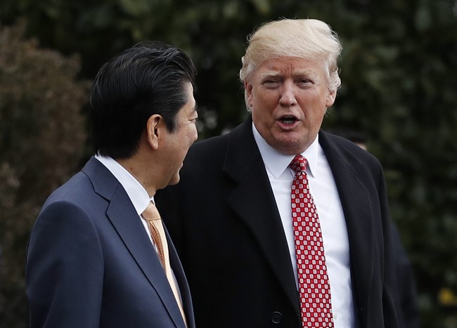 President Donald Trump talks to Japanese Prime Minister Shinzo Abe as they walk to board Marine One on the South Lawn of the White House in Washington, Friday, Feb. 10, 2017, for the short trip to Andrews Air Force Base, Md. en route to West Palm Beach, Fla.