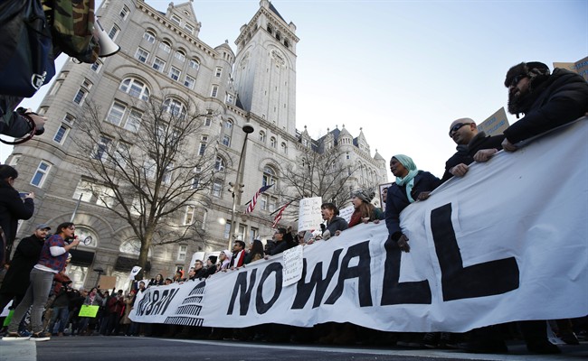 Protesters march along Pennsylvania Avenue past the Trump International Hotel during a rally protesting the immigration policies of President Donald Trump, near the White House in Washington, Saturday, Feb. 4, 2017.