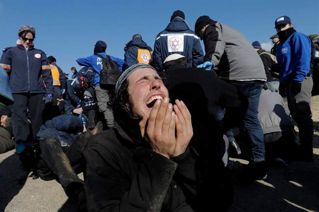 A settler reacts as police evict settlers from the West Bank outpost of Amona Thursday, Feb. 2, 2017.