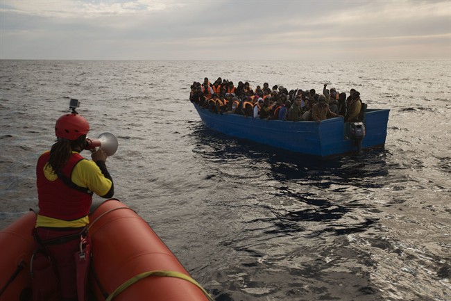 Migrants and refugees are assisted by members of the Spanish NGO Proactiva Open Arms, as they crowd aboard a boat sailing out of control in the Mediterranean Sea about 21 miles north of Sabratha, Libya, on Friday, Feb. 3, 2017. 