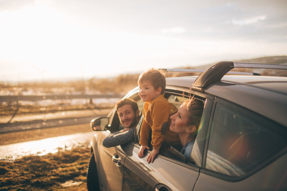 Photo of cute little family during their excursion with family car.